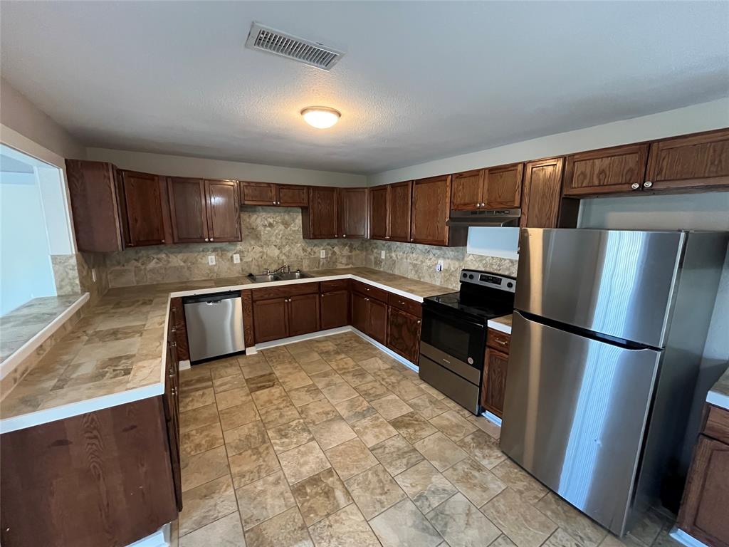 3006 Chiesa Road Rowlett, TX 75088 - Photo 11 of 33 a kitchen with granite countertop a refrigerator and a sink