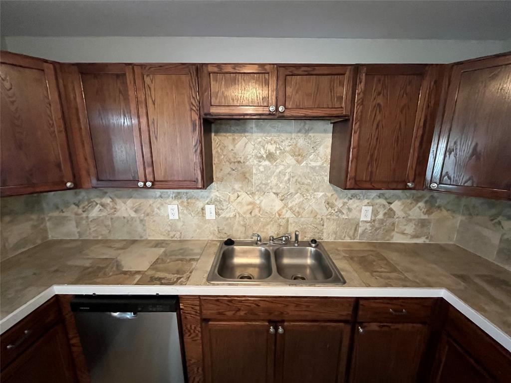 3006 Chiesa Road Rowlett, TX 75088 - Photo 12 of 33 a kitchen with stainless steel appliances granite countertop wooden cabinets a sink and dishwasher