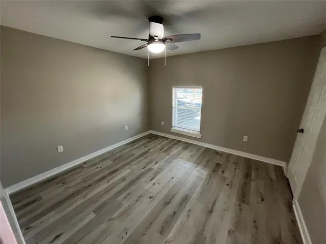 a view of an empty room with a chandelier fan
