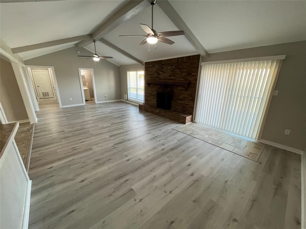 3006 Chiesa Road Rowlett, TX 75088 - Photo 6 of 33 an empty room with wooden floor fireplace and windows