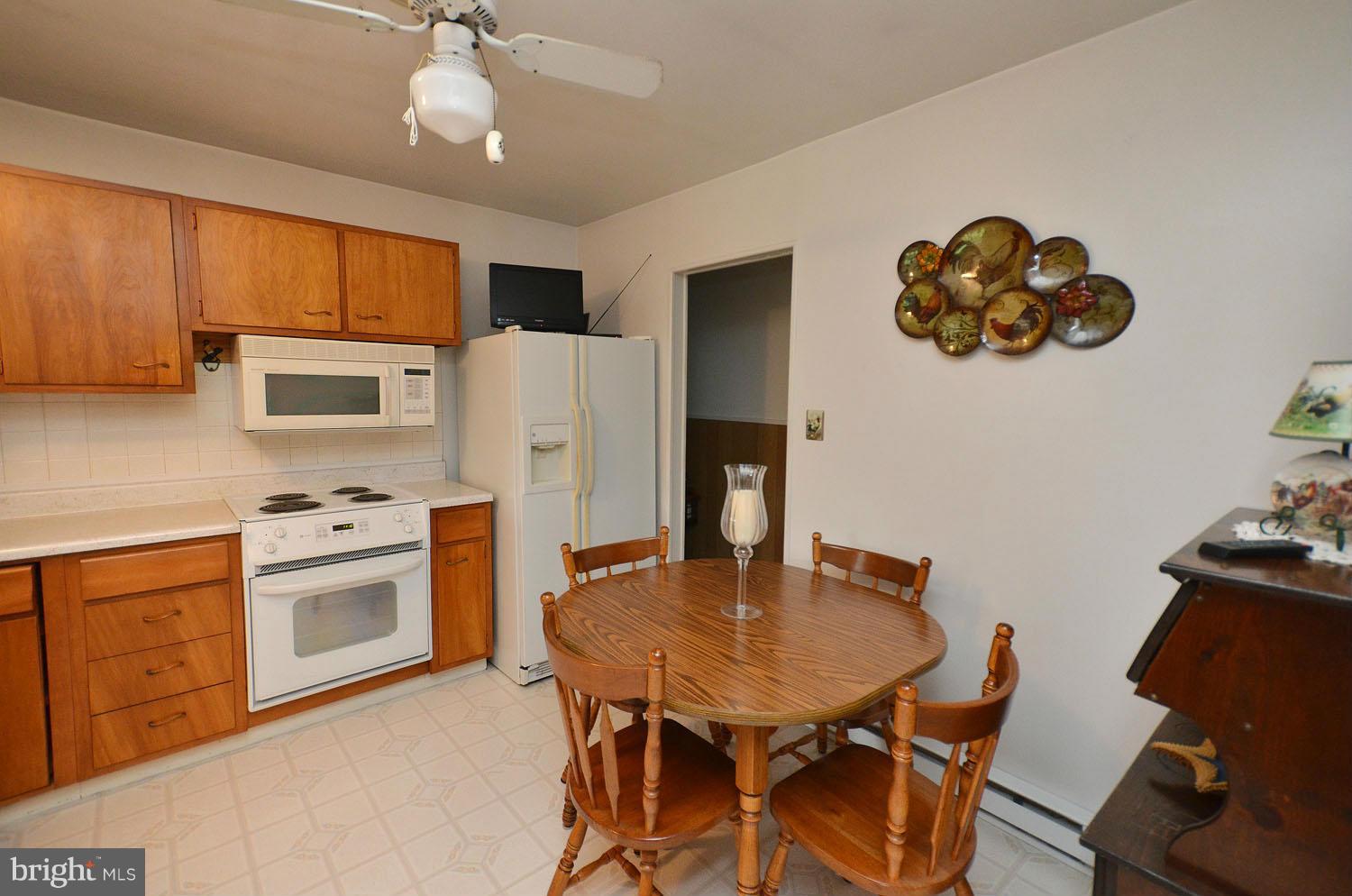 1008 South Hoga Road Sterling, VA 20164 - Photo 6 of 30 a kitchen with stainless steel appliances granite countertop a dining table chairs and a refrigerator