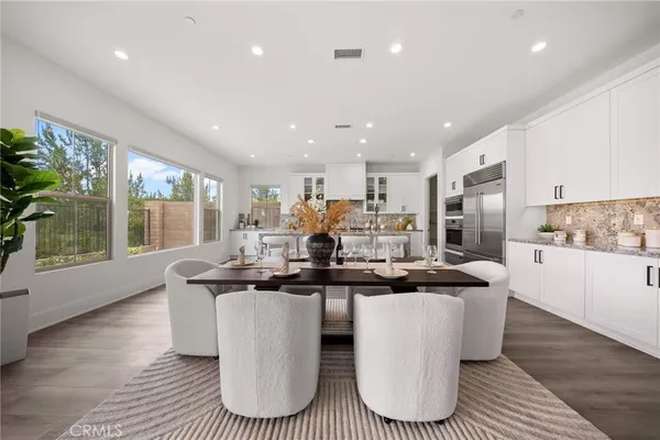 a kitchen with stainless steel appliances granite countertop a sink a stove a refrigerator cabinets and living room view