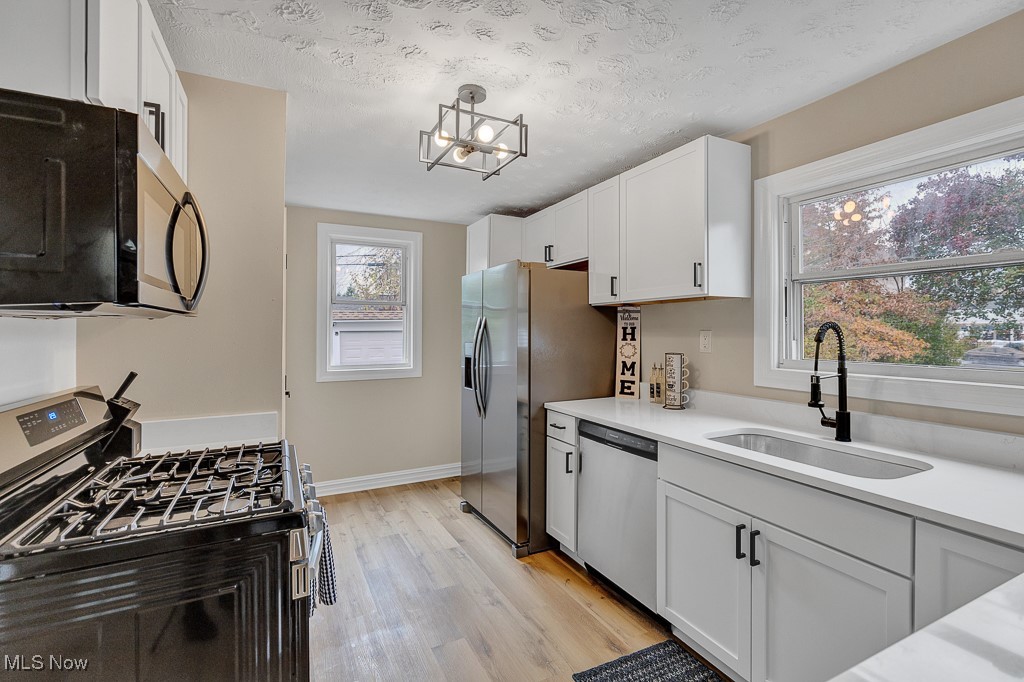 2127 Rossmoor Road Cleveland Heights, OH 44118 - Photo 19 of 21 Kitchen featuring a sink, white cabinetry, light countertops, and appliances with stainless steel finishes