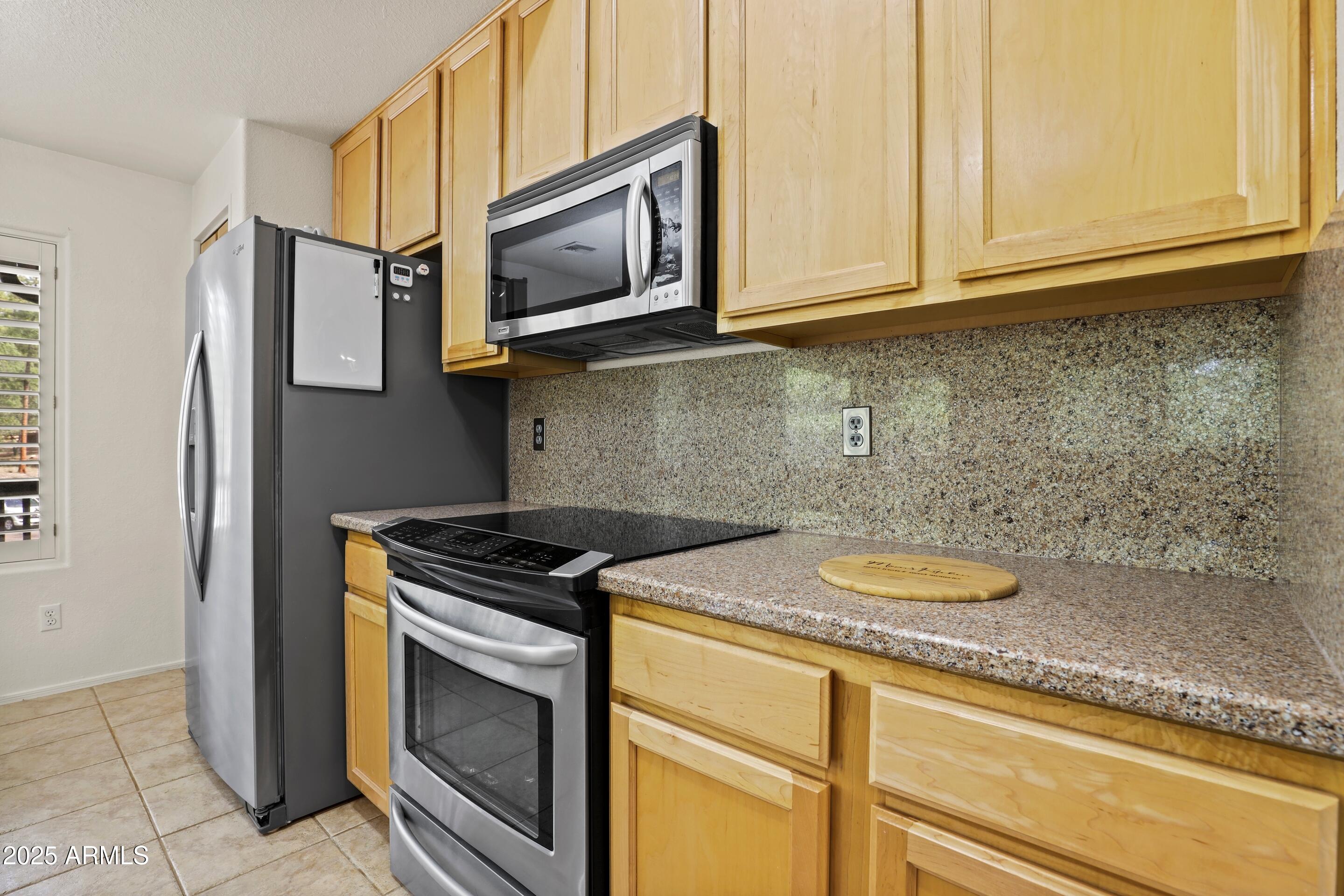 269 Homestead Lane Payson, AZ 85541 - Photo 22 of 38 a kitchen with stainless steel appliances granite countertop a stove a microwave and a sink