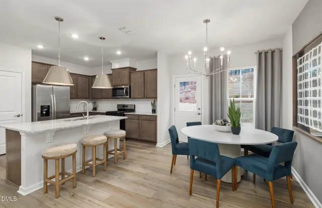 a kitchen with stainless steel appliances granite countertop a sink a stove a refrigerator and cabinets