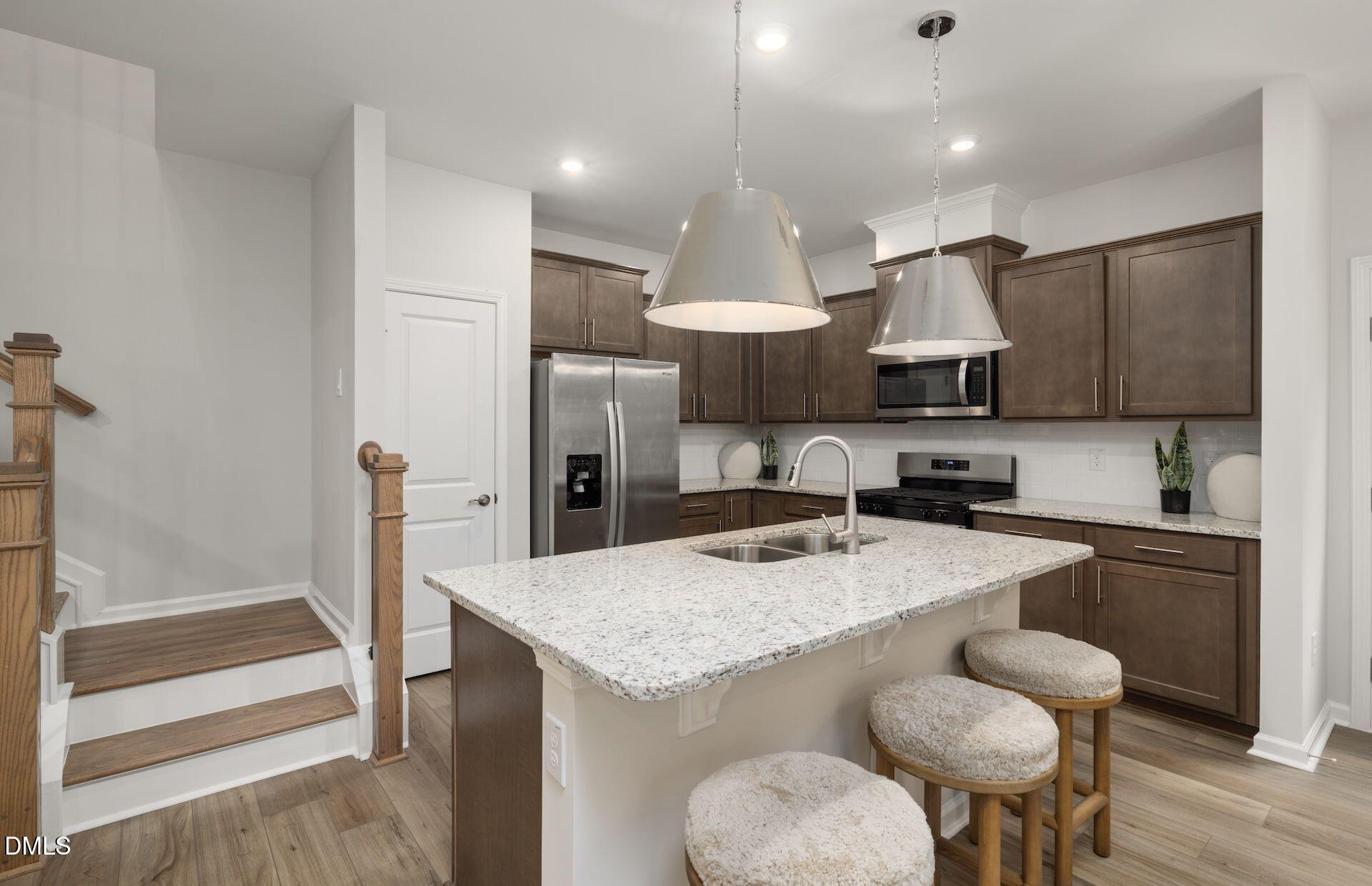 5007 Reader Way Durham, NC 27703 - Photo 5 of 31 a kitchen with stainless steel appliances granite countertop a sink a stove and a refrigerator