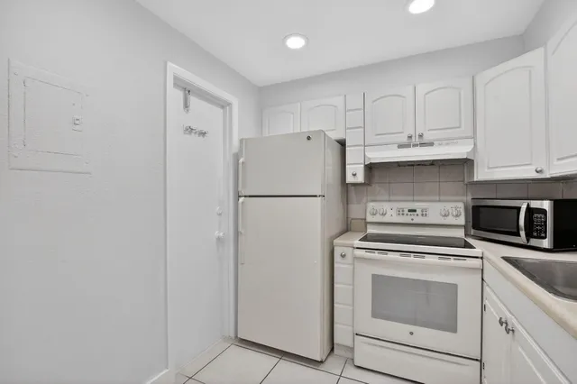 a kitchen with stainless steel appliances white cabinets and a refrigerator