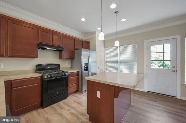 a kitchen with stainless steel appliances granite countertop a stove a sink and a refrigerator