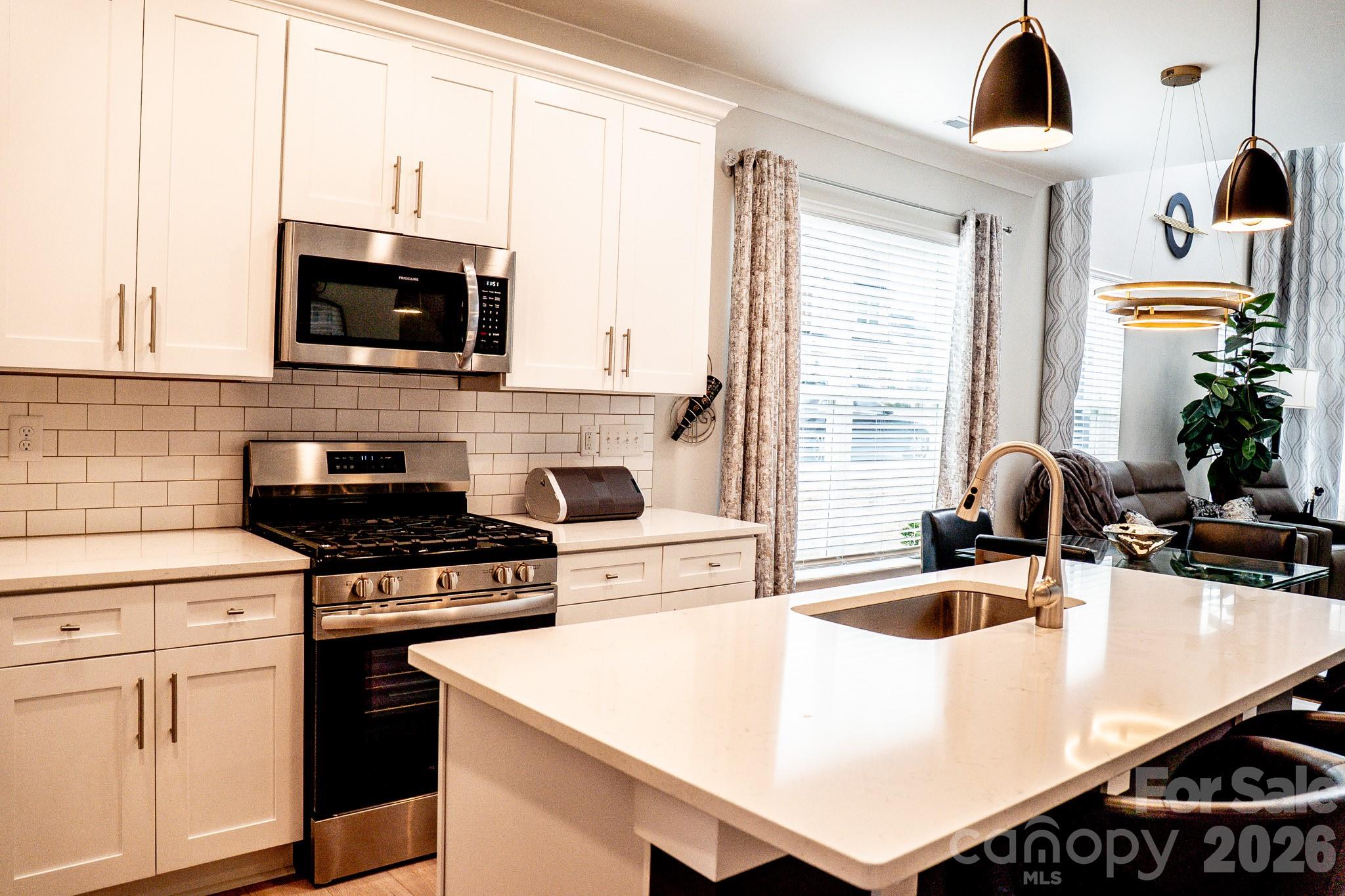 6288 Culbert Street Harrisburg, NC 28075 - Photo 4 of 40 a kitchen with a stove a sink and a microwave