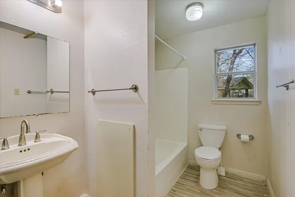 a bathroom with a toilet sink and mirror