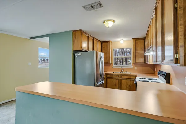 a kitchen with stainless steel appliances a refrigerator sink and wooden floor