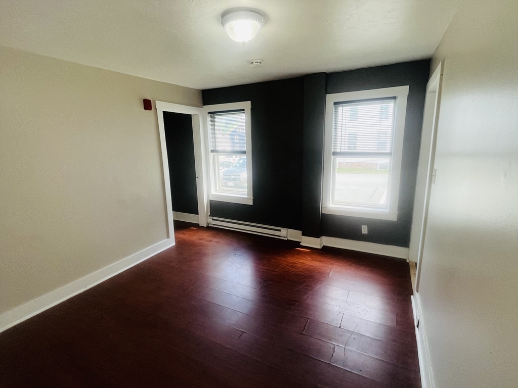 347 Main Street, Unit 2 Douglas, MA 01516 - Photo 3 of 5 an empty room with wooden floor and windows