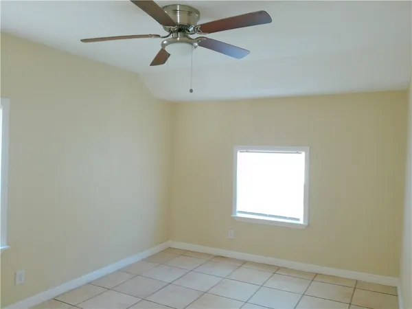 an empty room with a window and a fan