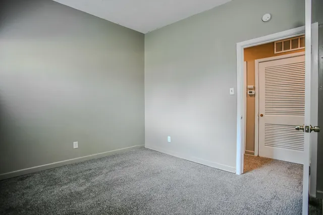 an empty room with closet and wooden door