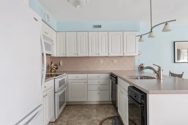 a kitchen with cabinets appliances a sink and a counter top