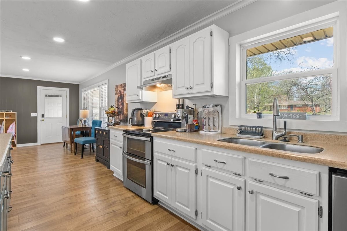 1112 Bridgette Street Paris, TN 38242 - Photo 11 of 34 a kitchen with white cabinets and wooden floor