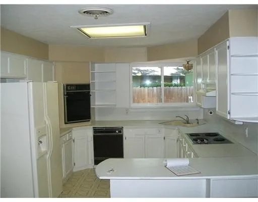 a kitchen with a sink a stove top oven and cabinetry