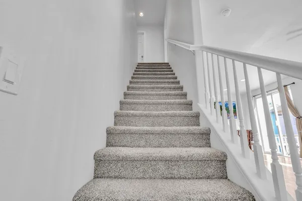 a view of staircase with white walls and windows