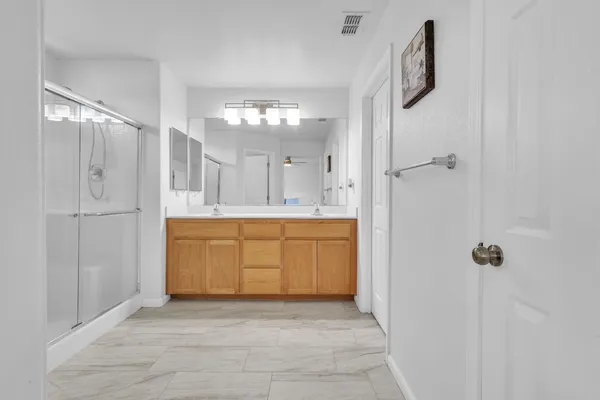 a bathroom with a granite countertop sink a mirror and a shower