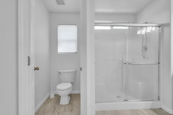 a bathroom with a toilet and a shower
