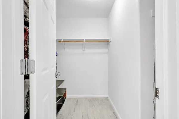 a view of walk in closet with empty racks