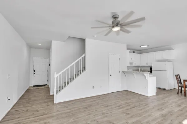 a view of a kitchen with wooden floor and a ceiling fan
