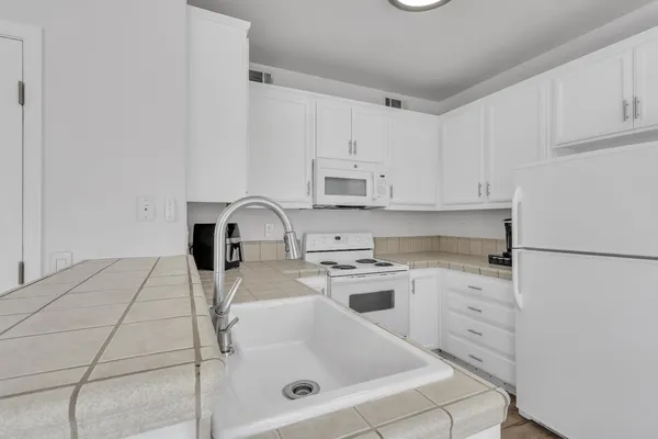 a kitchen with stainless steel appliances granite countertop a sink and a refrigerator