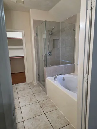 an empty room with a window and a ceiling fan