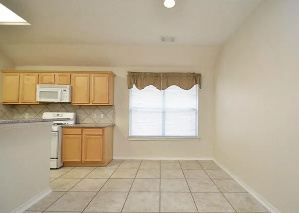 a kitchen with white cabinets sink and white appliances