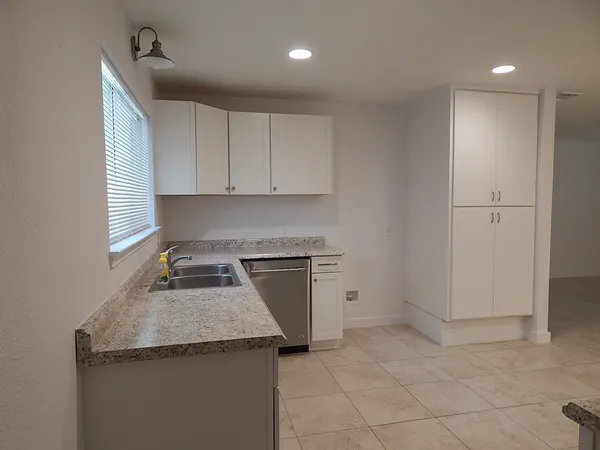 a kitchen with granite countertop a sink and a stove top oven