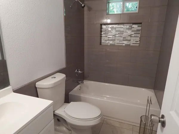 a white toilet sitting next to a bath tub