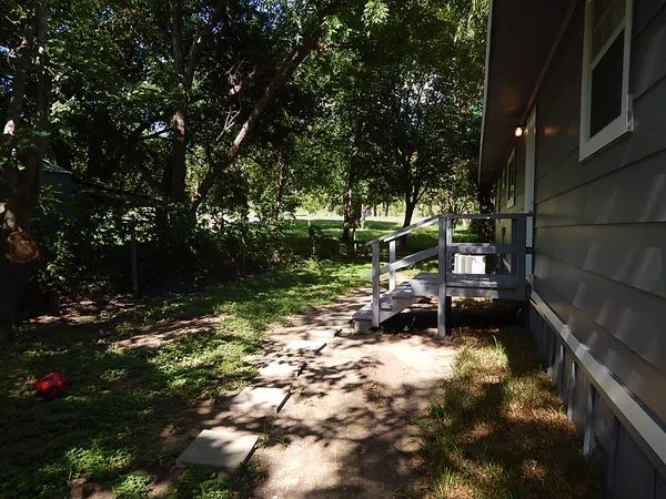 a backyard of a house with lots of green space and fountain