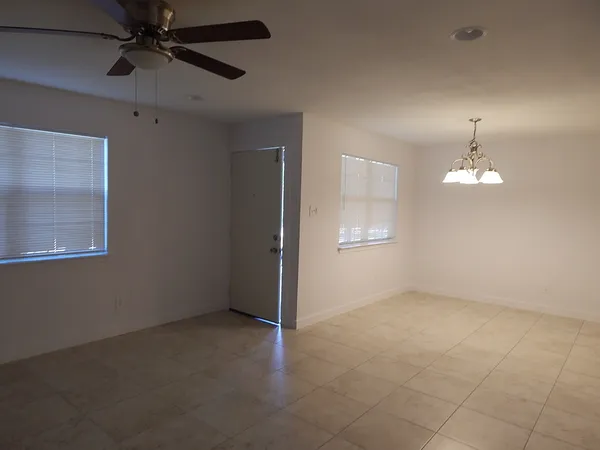 an empty room with chandelier fan