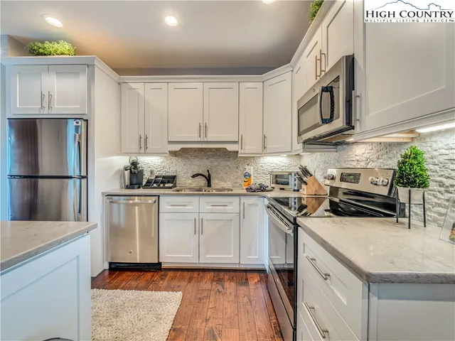 a kitchen with stainless steel appliances granite countertop a refrigerator sink and stove