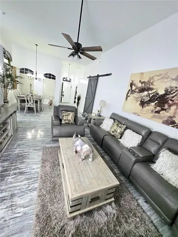 a living room with furniture a flat screen tv and kitchen view