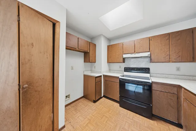 a kitchen with granite countertop a sink cabinets stainless steel appliances and a window