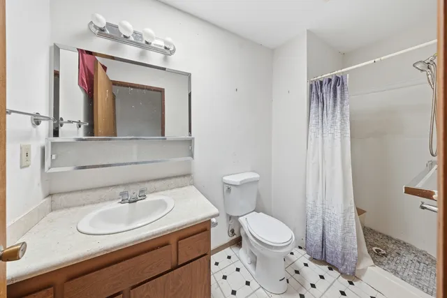 a bathroom with a sink toilet a mirror and shower