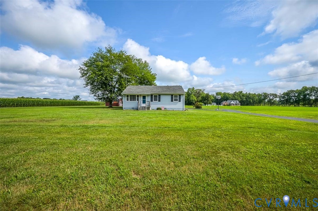 581 Smokey Road Aylett, VA 23009 - Photo 2 of 28 Expansive green lawn surrounds a light-colored hom