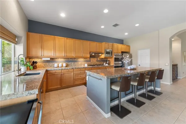 a kitchen with kitchen island granite countertop wooden cabinets a dining table and chairs