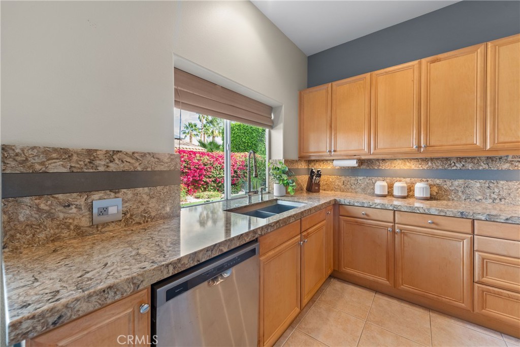 70 Rocio Court Palm Desert, CA 92260 - Photo 17 of 40 a kitchen with stainless steel appliances granite countertop sink window and cabinets