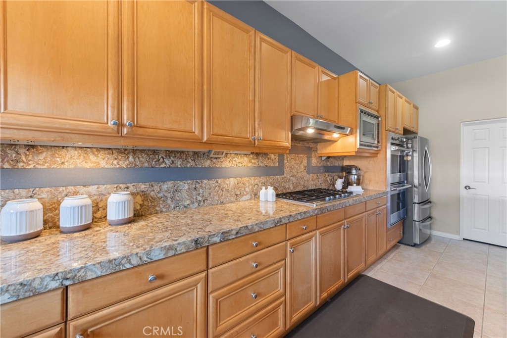 70 Rocio Court Palm Desert, CA 92260 - Photo 18 of 40 a kitchen with granite countertop cabinets and white appliances
