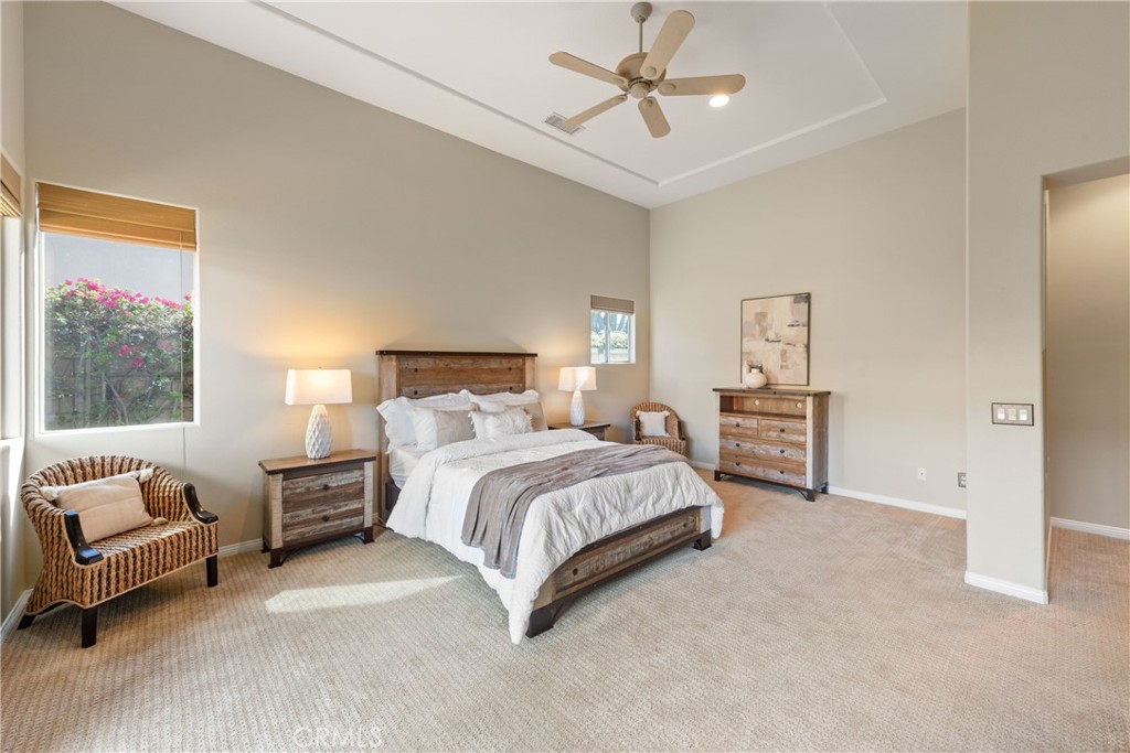 70 Rocio Court Palm Desert, CA 92260 - Photo 22 of 40 a spacious bedroom with a bed a couch and a window