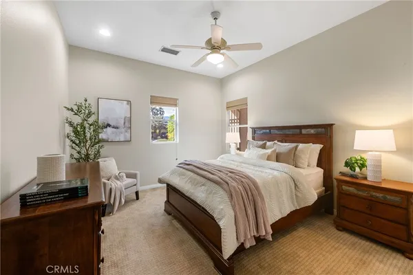 a bedroom with a bed and a potted plant on the dresser
