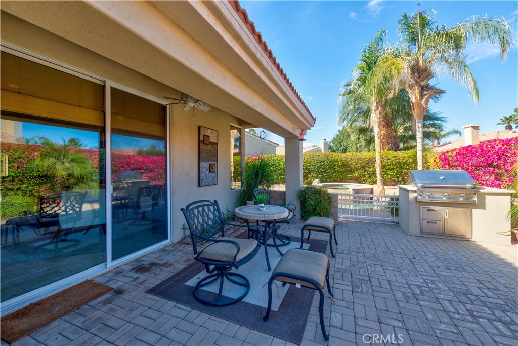 70 Rocio Court Palm Desert, CA 92260 - Photo 33 of 40 a view of a patio with a dining table and chairs with wooden floor