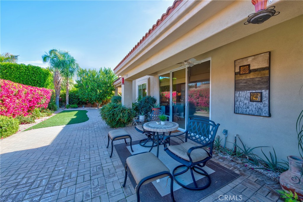 70 Rocio Court Palm Desert, CA 92260 - Photo 34 of 40 a view of a patio with table and chairs potted plants and floor to ceiling window