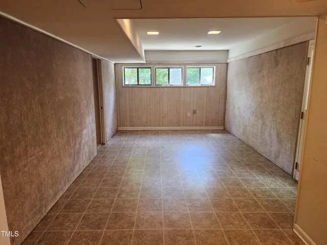a view of hallway with a window and wooden floor
