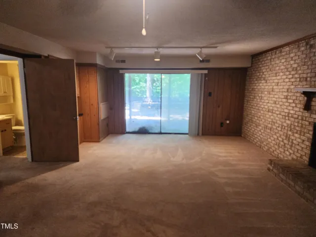 a view of room with large windows and a ceiling fan