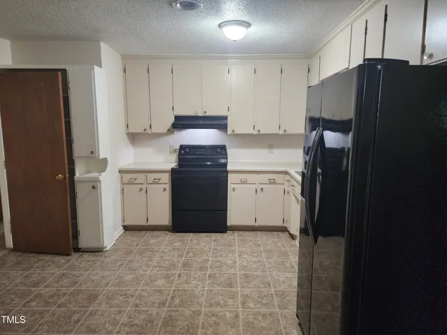 a kitchen with granite countertop a refrigerator and a sink