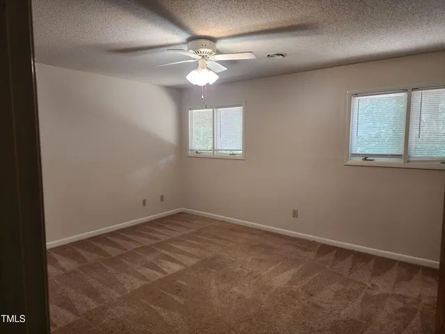 an empty room with a chandelier fan