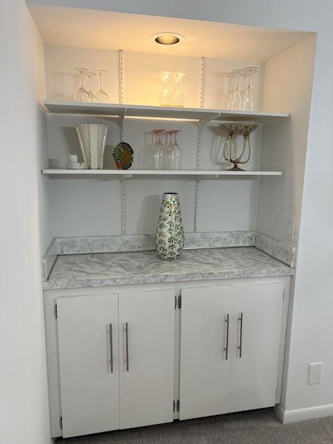 1605 Highway 1, Unit F305 Jupiter, FL 33477 - Photo 14 of 31 a kitchen with white cabinets and a wooden floor